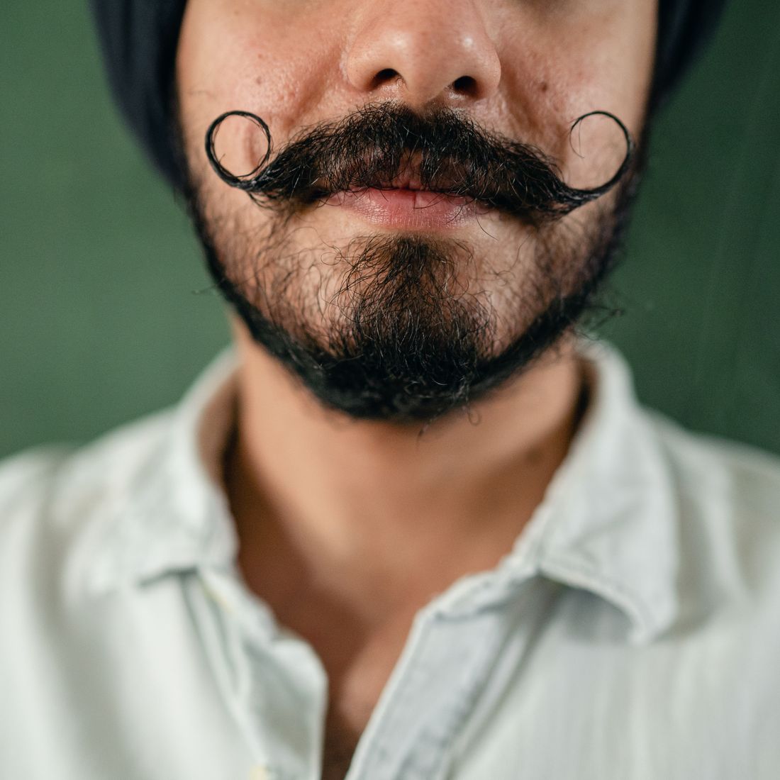 Hombre con bigote manillar, de puntas largas retorcidas hacia arriba con cera